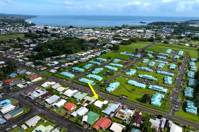 an aerial view of residential houses with outdoor space and trees