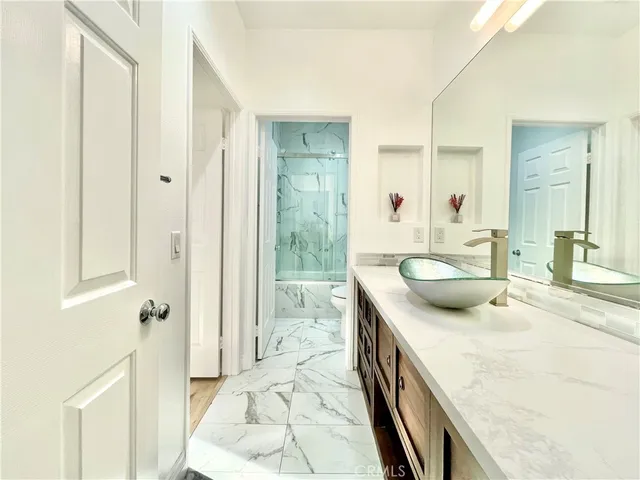 a spacious bathroom with a granite countertop sink a mirror and shower