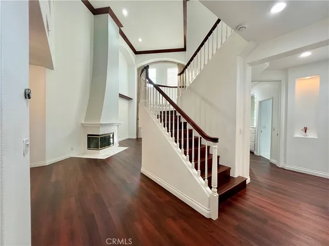 a view of staircase with wooden floor and fan