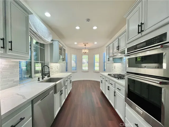 a large kitchen with stainless steel appliances wooden floor and stainless steel appliances