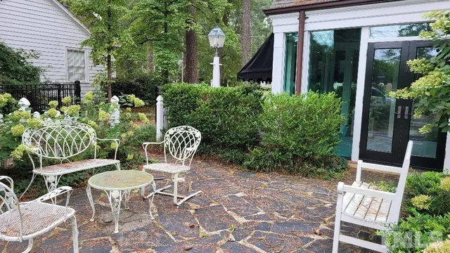 a view of a patio with table and chairs and potted plants