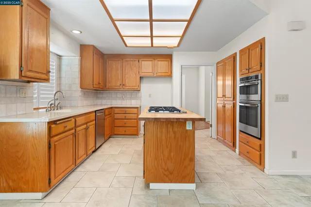 a kitchen with stainless steel appliances granite countertop a refrigerator and a sink