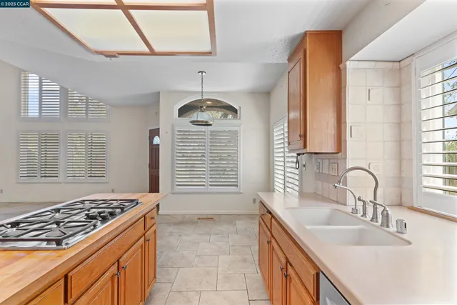 a kitchen with kitchen island a sink stove top oven and cabinets