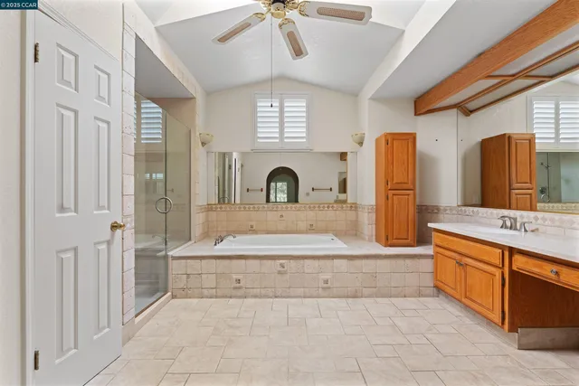 a spacious bathroom with a granite countertop sink a toilet mirror and bathtub