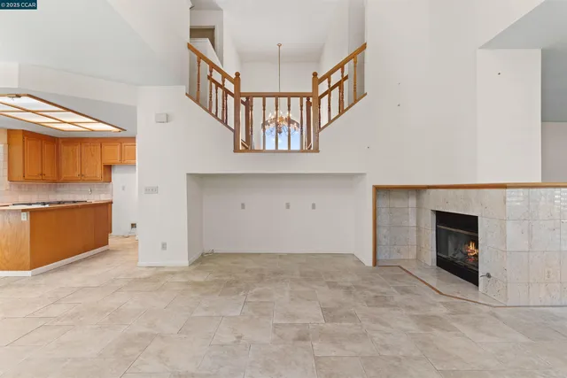 a view of an empty room with a fireplace and a window