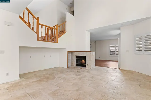 an empty room with windows and a fireplace