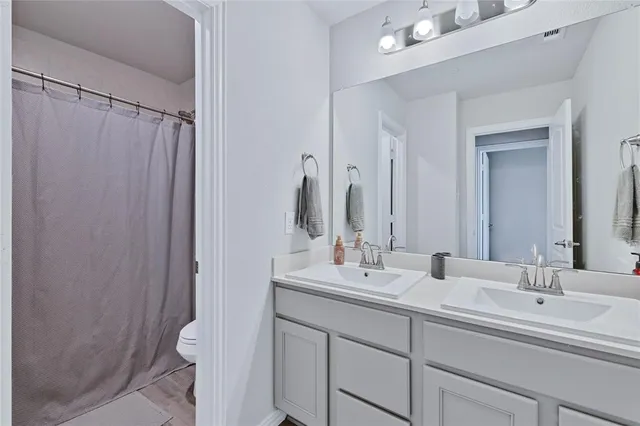 a bathroom with double vanity sink and a mirror