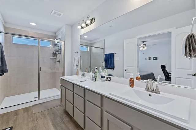 a bathroom with double vanity sinks double vanity shower and a mirror