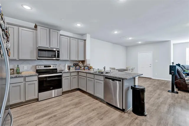 a kitchen with granite countertop a stove top oven and cabinets