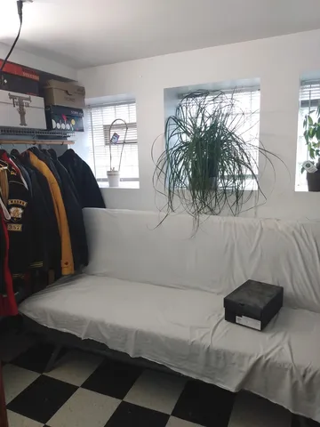 a room with a black white checkered floor with a gaming machine and a rug