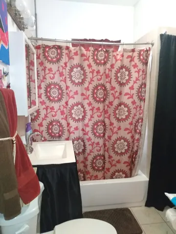 a bathroom with a toilet and a shower curtain
