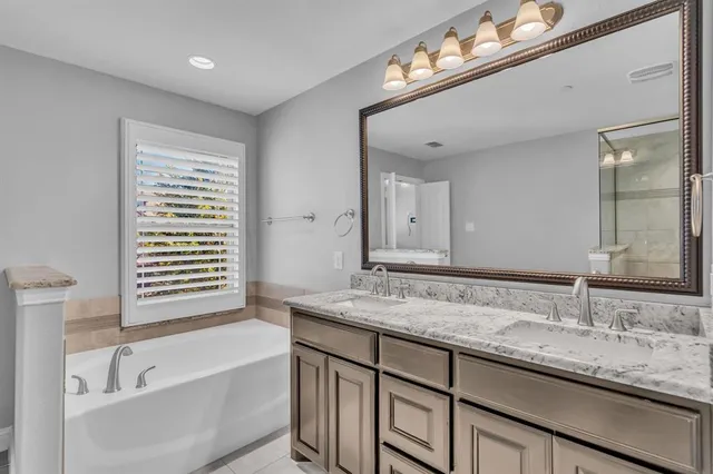 a bathroom with a granite countertop sink a mirror and shower