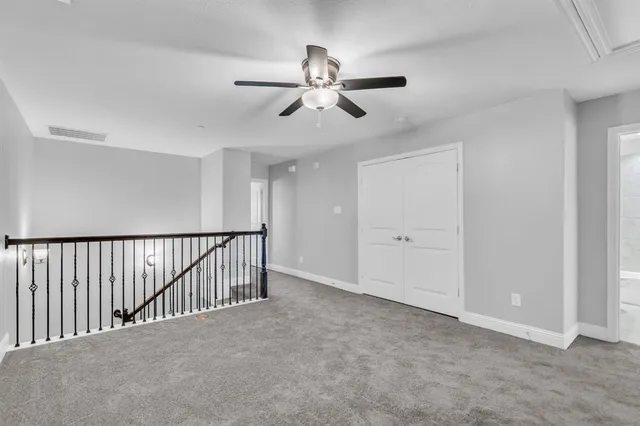 a view of staircase with a ceiling fan and window
