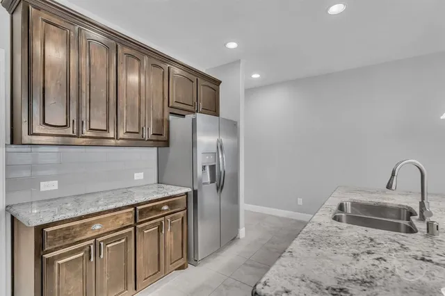 a kitchen with stainless steel appliances granite countertop a stove a sink and a wooden floors