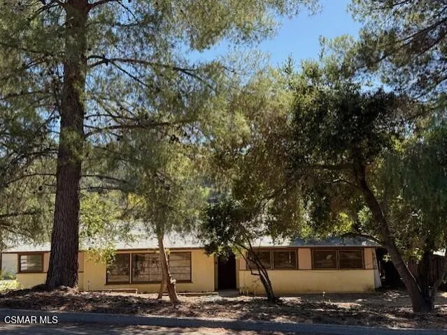 a front view of a house with trees