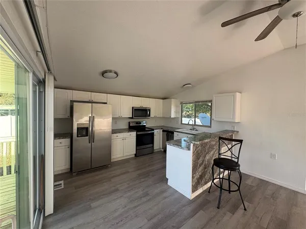 a kitchen with refrigerator cabinets and wooden floor