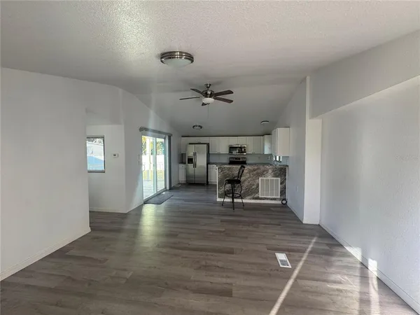 a view of a livingroom with wooden floor and a ceiling fan