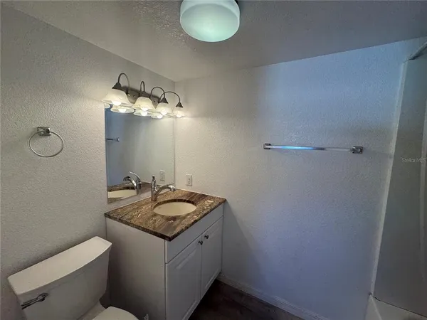 a bathroom with a granite countertop sink and a mirror