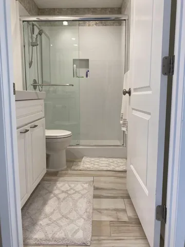 a view of a patio with table and chairs and couches with wooden floor