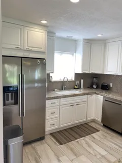 a kitchen with stainless steel appliances granite countertop a refrigerator sink and cabinets
