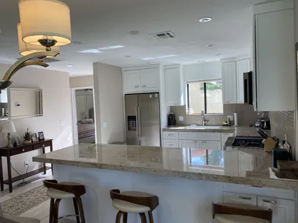 a kitchen with cabinets and chairs