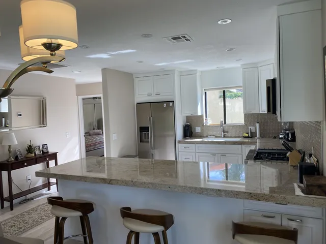 a kitchen with cabinets and chairs