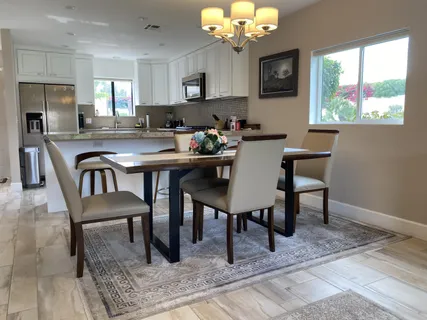 a view of a dining room with furniture a rug and a chandelier