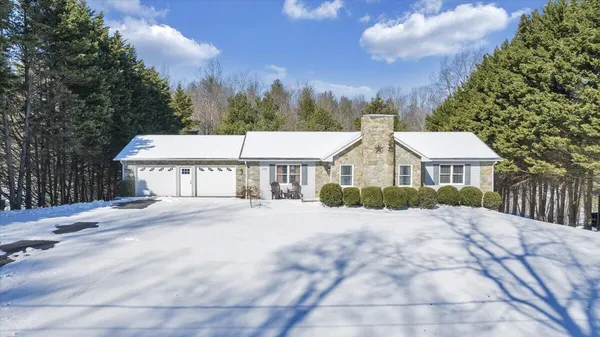 a front view of a house with a yard and trees