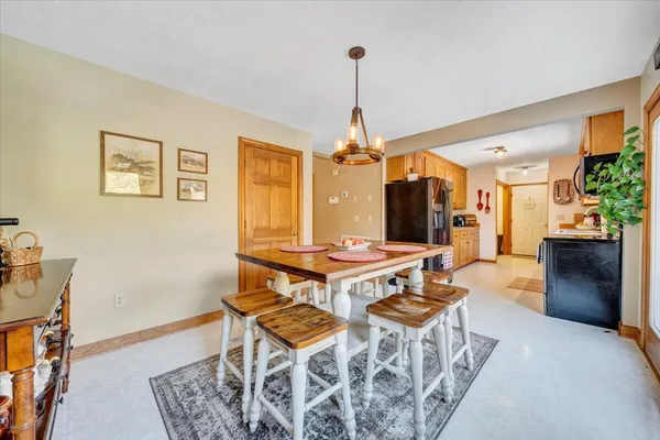 a kitchen with stainless steel appliances a refrigerator a stove a sink and dishwasher with a dining table