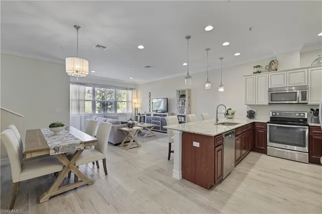 a large kitchen with lots of furniture a sink appliances and a dining table