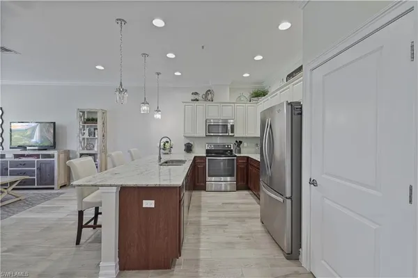 a kitchen with stainless steel appliances granite countertop refrigerator sink and stove