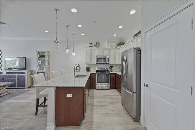 a kitchen with stainless steel appliances granite countertop refrigerator sink and stove