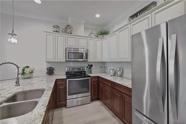 a kitchen with stainless steel appliances granite countertop a refrigerator sink and stove
