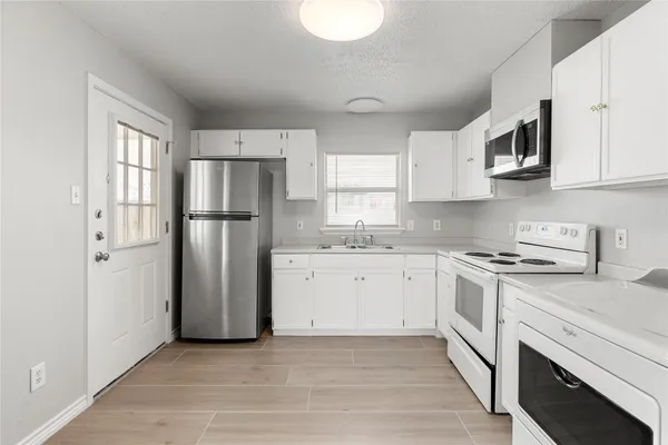 a kitchen with stainless steel appliances granite countertop a refrigerator sink and stove