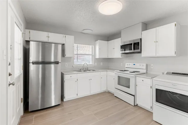 a kitchen with cabinets stainless steel appliances and a window