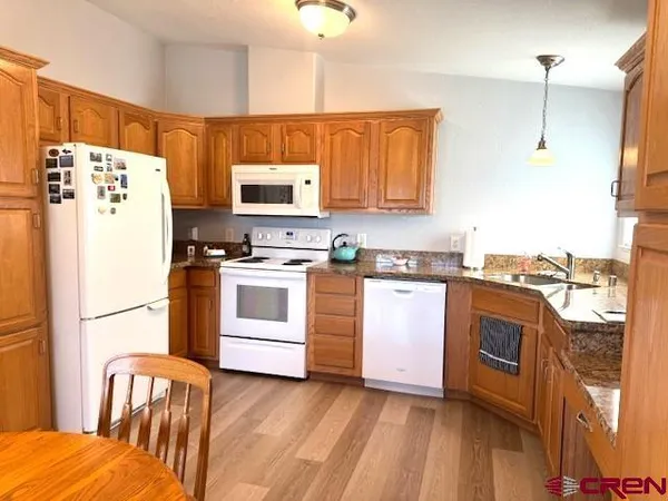 a kitchen with stainless steel appliances white cabinets and wooden floor
