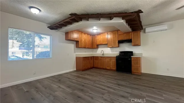 a kitchen with granite countertop a stove and a wooden floor