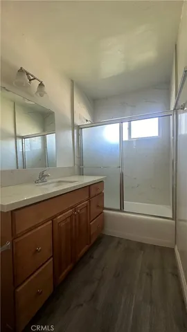a spacious bathroom with a granite countertop sink a toilet a mirror and shower