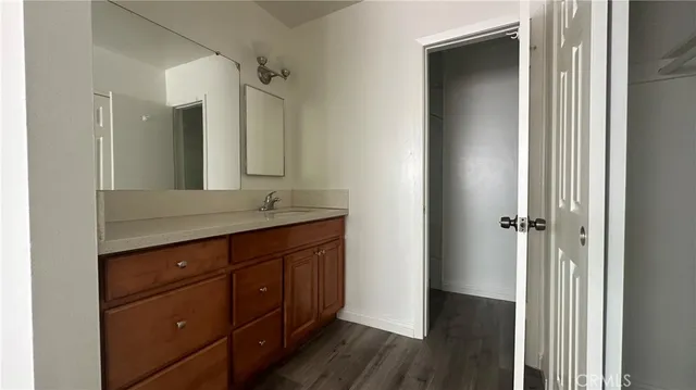 a bathroom with a granite countertop sink mirror and cabinets