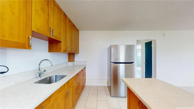 a kitchen with stainless steel appliances granite countertop a sink a refrigerator and a stove top oven