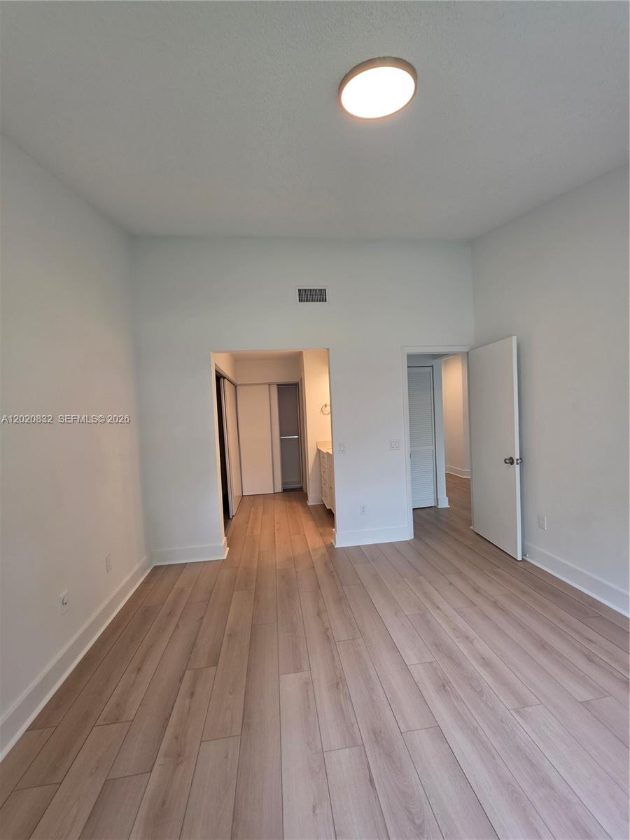 15240 Southwest 45th Terrace, Unit 54F Miami, FL 33185 - Photo 36 of 48 a view of empty room with wooden floor and fan