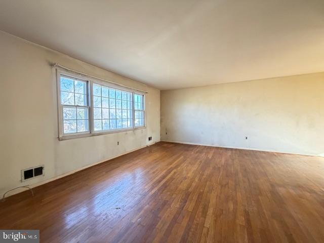 8909 Keewatin Road Lanham, MD 20706 - Photo 3 of 18 an empty room with wooden floor and windows