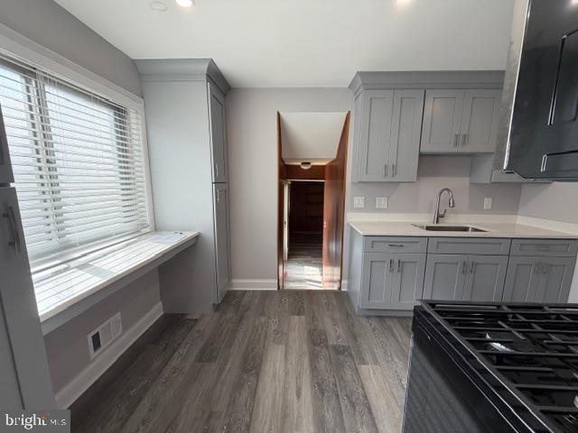 8909 Keewatin Road Lanham, MD 20706 - Photo 6 of 18 a kitchen with granite countertop a stove a sink and wooden floor