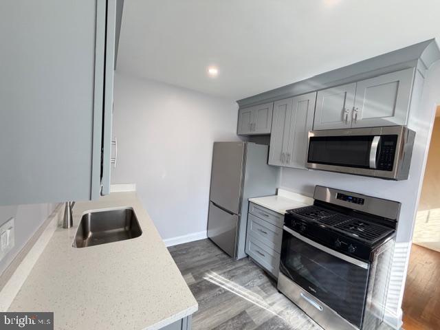 8909 Keewatin Road Lanham, MD 20706 - Photo 8 of 18 a kitchen with stainless steel appliances a stove a microwave and a sink