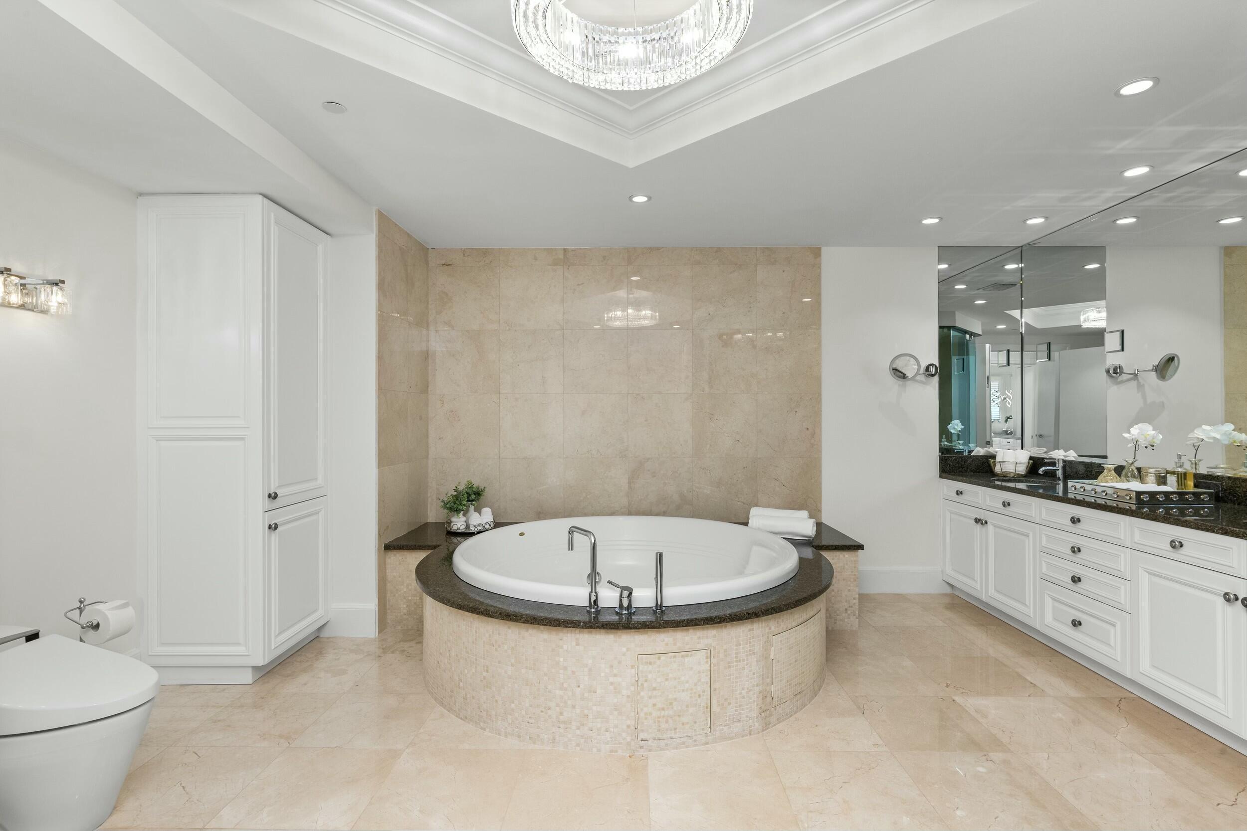 2500 South Ocean Boulevard, Unit 903 Boca Raton, FL 33432 - Photo 36 of 66 a bathroom with a granite countertop sink a toilet a mirror and bathtub