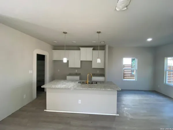 a view of kitchen with kitchen island a sink and a stove