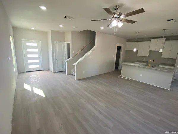 a view of a livingroom with a ceiling fan and wooden floor