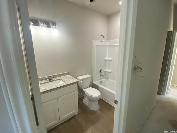 a bathroom with a granite countertop toilet and sink