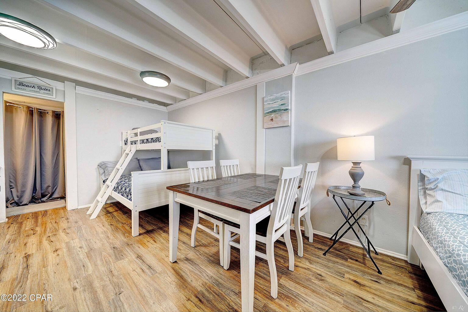 14401 Front Beach Road, Unit 434 Panama City Beach, FL 32413 - Photo 3 of 36 a room with wooden floor table and chairs