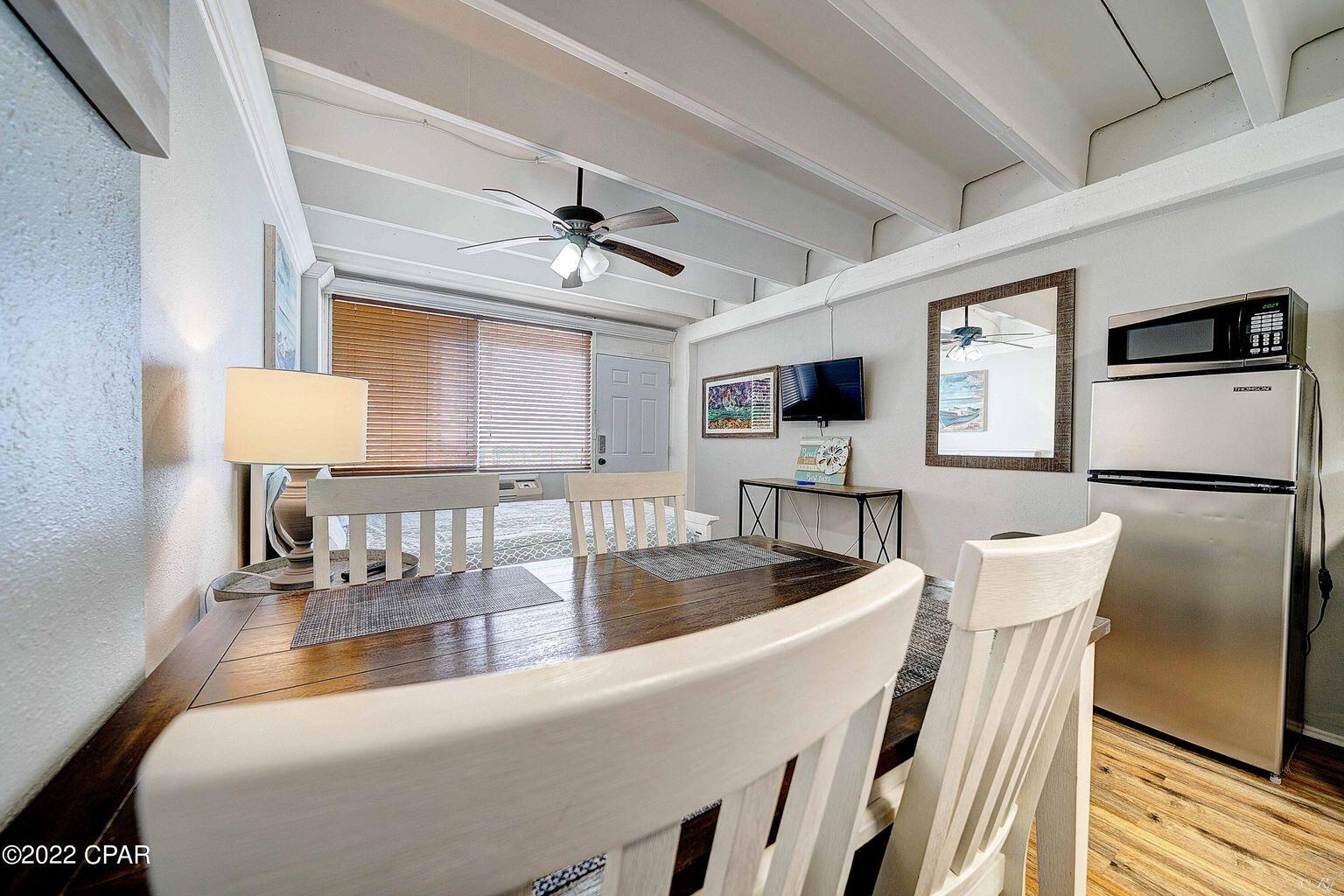 14401 Front Beach Road, Unit 434 Panama City Beach, FL 32413 - Photo 7 of 36 a view of a dining room with furniture a chandelier and wooden floor